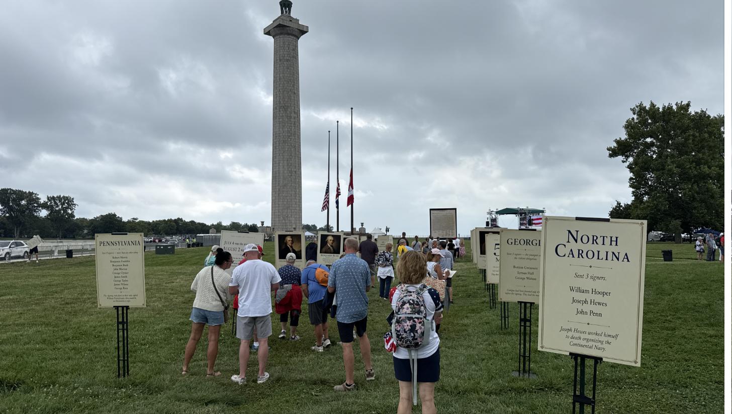 Visitors reading the state signer boards beneath Perry's Victory Monument